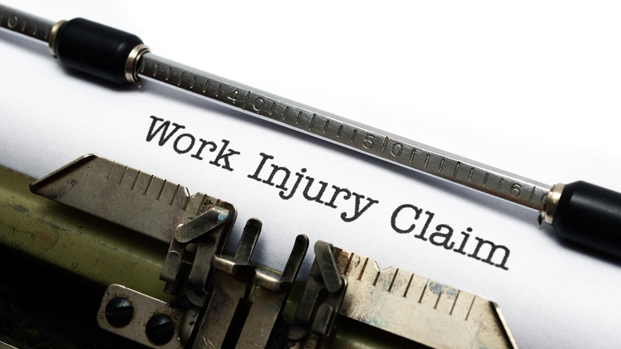 Typewriter with the words work injury claim typed on a piece of paper - workers compensation insurance Lake Charles La - Kelly Lee Insurance